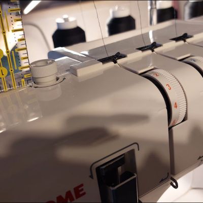 De persvoetdruk van de coverlock  instellen/verhogen-verlagen